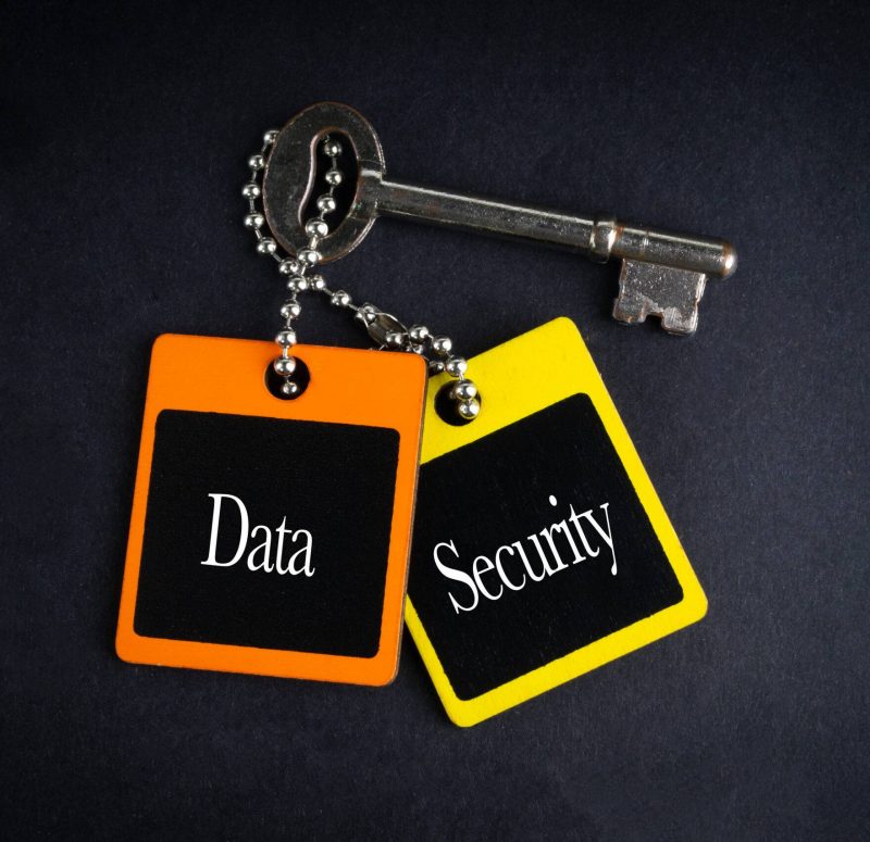 DATA SECURITY inscription written on wooden tag and key on black background with selective focus and crop fragment. Business and education concept RG05F2 DATA SECURITY inscription written on wooden tag and key on black background with selective focus and crop fragment. Business and education concept