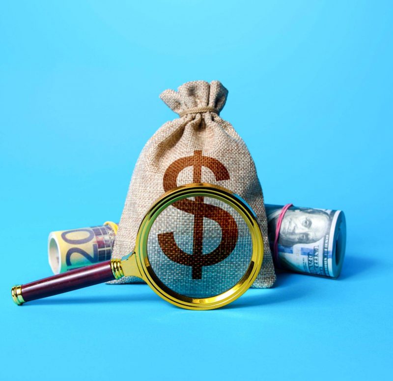 Dollar money bag and magnifying glass. Investigating capital origins. Anti money laundering and tax evasion. Find investment funds for business projec 2H5M77P Dollar money bag and magnifying glass. Investigating capital origins. Anti money laundering and tax evasion. Find investment funds for business projec