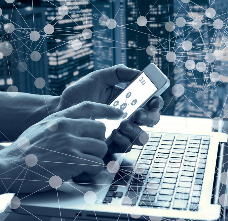 Data and modern technology concept with a person touching a mobile phone screen and using a computer with abstract network diagram HH70DG Data and modern technology concept with a person touching a mobile phone screen and using a computer with abstract network diagram