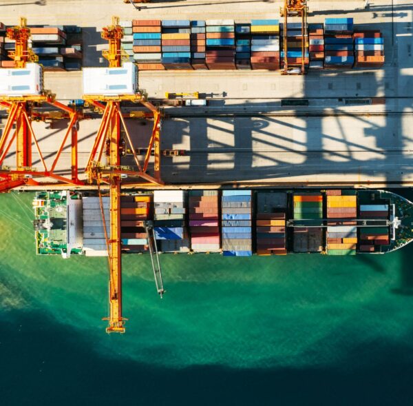 Aerial view of containers loading and unloading to the ship in the sea port. Logistic and transportation of goods. Crisis and shortage of containers in the world.